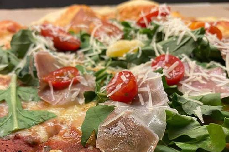 Italiana Pizza - Tomato Sauce, Mozzarella, Arugula, Cherry Tomato, Serrano Ham and Parmesan.